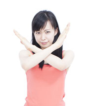 ×のサインをする女性